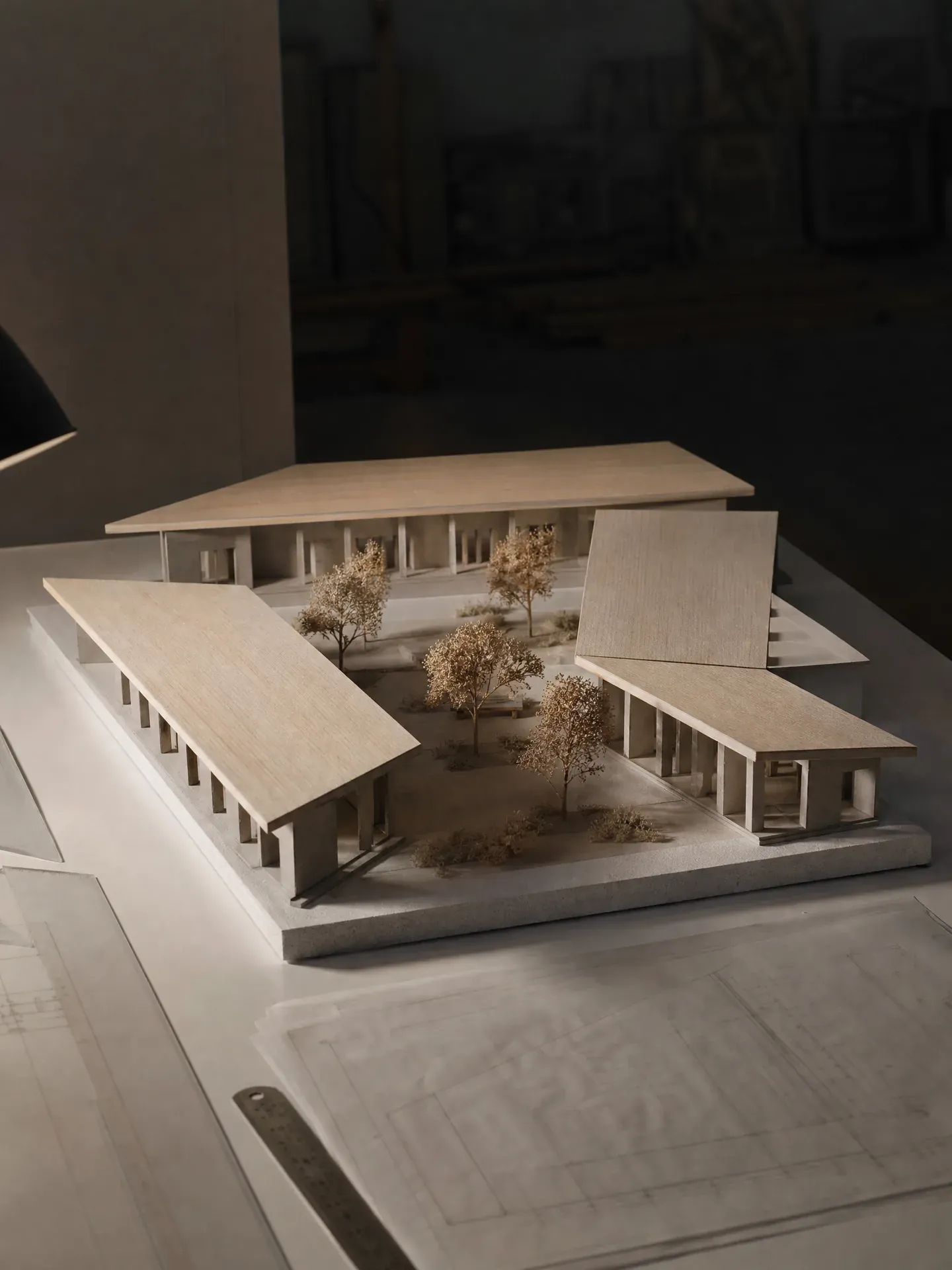Maquette d'étude en carton gris d'un groupe scolaire autour d'une cour plantée